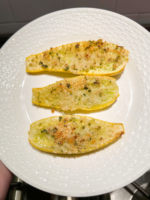 three slices of yellow squash baked with parmesan cheese and breadcrumbs on a white plate