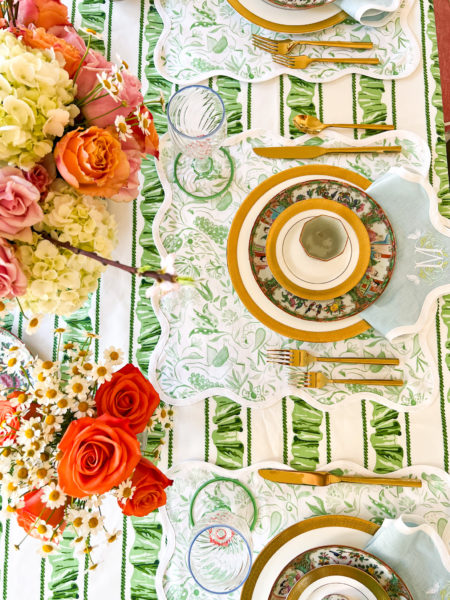 table setting for st patricks day fancy meal with green and white tablecloth green and white placemats gold and white plates and orange and pink roses