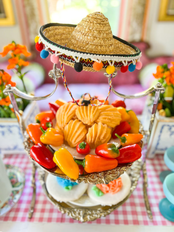 silver tiered tray with cheese wafers on top level and cookies on lower level with mini sombrero on top of serving piece