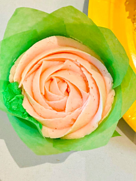 pink rose cupcake with green leaves and paper wrapper