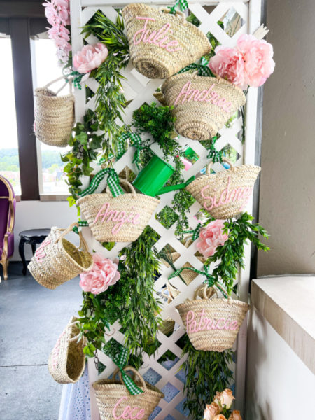 white lattice with greenery flowers and straw bags with names monogrammed