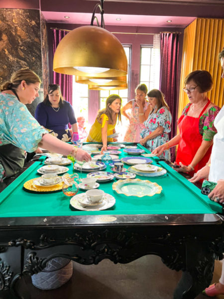 ladies working with fine china dishes on a pool table