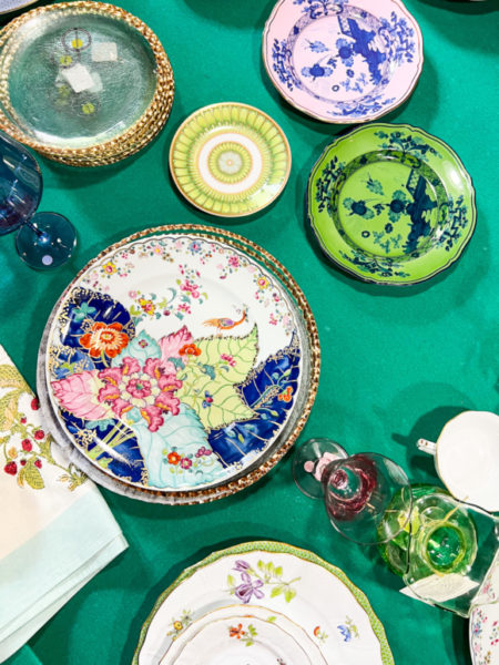 colorful china patterns on display on a green table