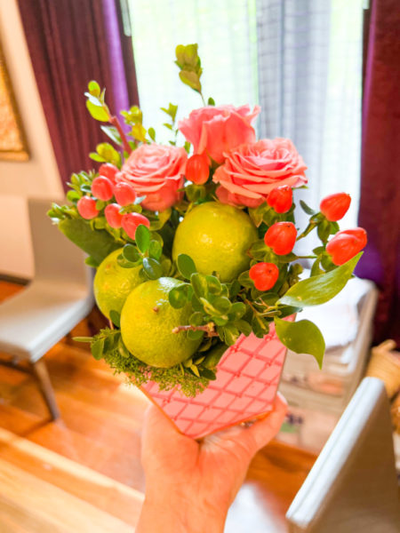 flower arrangement with pink roses and small green limes