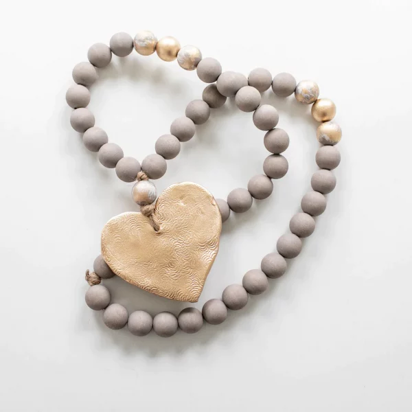 wooden beads on a long twine string painted taupe with a gold heart as large charm
