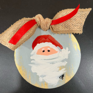 handpainted wooden ornament with santa on it and tied with burlap ribbon