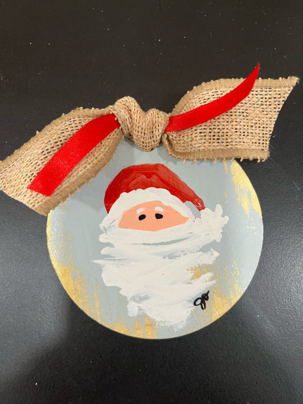 handpainted wooden ornament with santa on it and tied with burlap ribbon