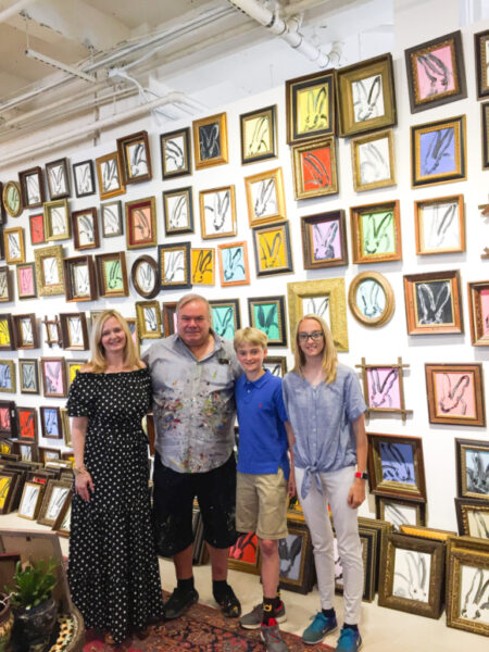 hunt slonem in his studio in front of bunny wall with lady and her son and daughter