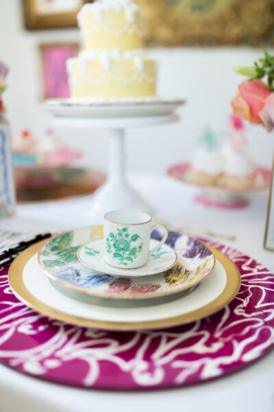 table set with butterfly plate bunny placemat and antique china surrounded by beautiful cakes