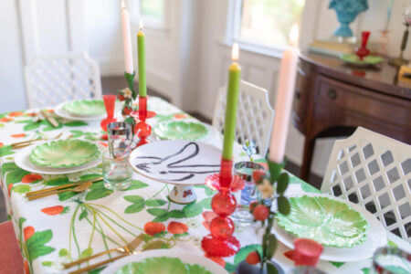 mothers day table set with straberry themed fabric red candle holders and green and white plates