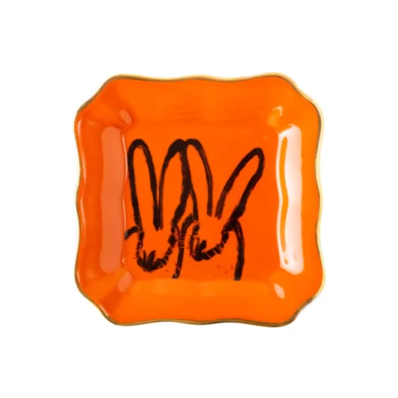 orange square plate with two bunnies painted on in black