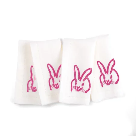 four white napkins with pink bunnies embroidered on each