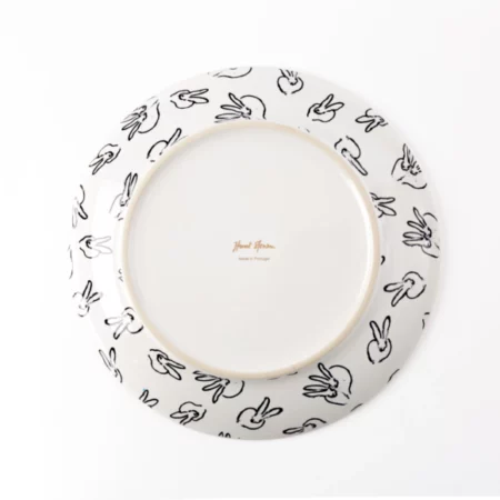 back of white plate shows many rabbits running around