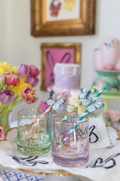 bunny glasses with butter fly straws on table with cake and flower display